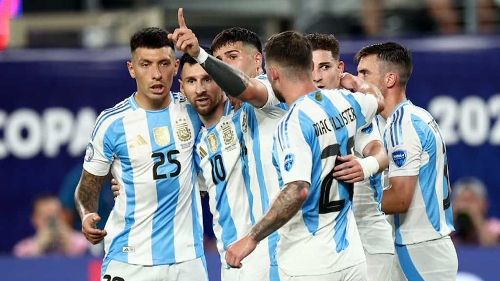 Argentinian soccer players celebrate together on the field, arm around each other, wearing light blue and white striped uniforms.